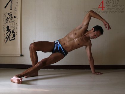 Balancing in side plank pose, both feet on the floor and hips lifted. Neil Keleher. Sensational Yoga Poses.