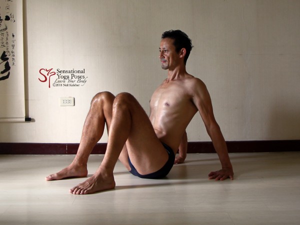 Table top preparation with hips on the floor and hands on the floor behind the back with fingers pointing forwards and shoulders activated so that they cause the chest to lift. Shoulder blades are retracted and depressed. Neil Keleher. Sensational Yoga Poses.