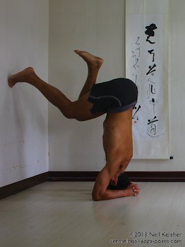 inverted yoga pose, balancing in headstand while using the wall