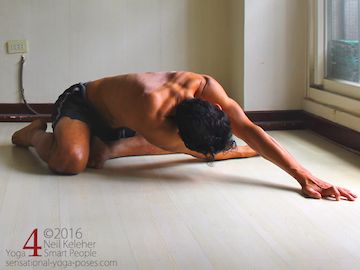 yoga shoulder stretch while bent forwards using the easy bharadvajasana foot position (semi kneeling position.)