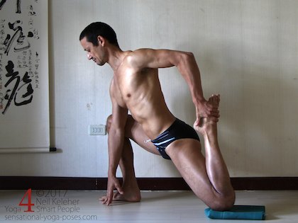 Lunging bent knee hip flexor stretching yoga pose, pulling the foot forwards.. Neil Keleher. Sensational Yoga Poses.