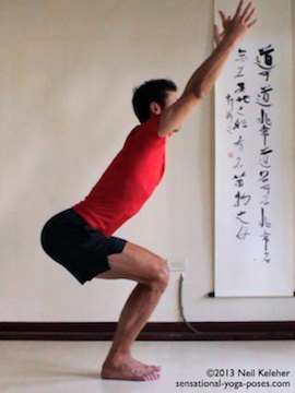 , yoga standing poses, chair pose, utkatasana. In this picture of chair yoga pose I'm standing with feet slightly separared. Knees are bent slightly more than 90 degrees with the thighs nearly horizontal. The low back is slightly arched and chest is lifted. Both arms are reaching up past the head with elbows straight and palms together. In this picture the gaze is forwards.