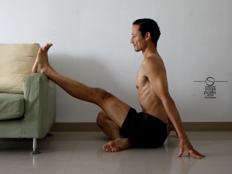Seated hamstring stretching yoga pose with one leg supported and stretched. Seated hamstring stretching yoga pose with one leg supported and stretched. Neil Keleher, Sensational Yoga Poses.