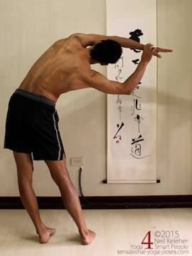 moon pose, chandrasana, standing side bend with feet hip width and arms overhead, bottom hand grabbing the top hand with elbow of top arm straight