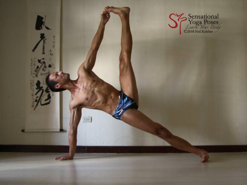 Side plank yoga pose: elbows and knee are straight. Torso is inline with the supporting leg. Supporting shoulder is stacked over support wrist. Top leg is flexed upwards with the big with grabbed by the same side hand. Gaze is directed upwards with head in line with the torso.  Neil Keleher. Sensational Yoga Poses.