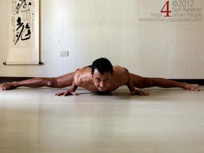 Middle splits. In this version I'm using my arms to help support my body in a push up like position. Neil Keleher. Sensational Yoga Poses.