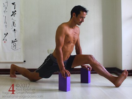Front to back splits, a forward bend for the front leg with hands on yoga blocks. Neil Keleher. Sensational Yoga Poses.