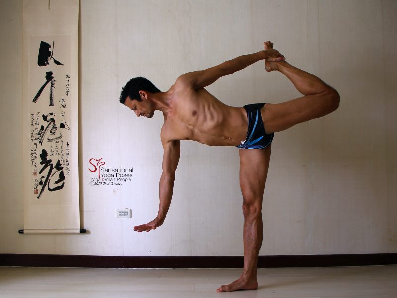 Sensational Yoga Poses, Model Neil Keleher. Balancing on one foot in the dancer position or standing bow with the torso tilted forwards and the other foot being grabbed behind the back. Free hand is reaching forwards.