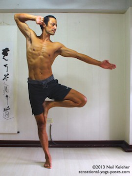 Sensational Yoga Poses, Model Neil Keleher. balancing on one leg in tree pose with the arms in a modified archer position, one arm straight the other arm bent as if pulling a bow string.